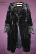 A striking vintage black fur coat having wide sleeve openings with turn up and shawl collar,serviced