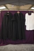 An assortment of vintage clerical garments including heavy wool cape.
