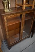 An early 20th Century part walnut low bookcase, glass missing to one door