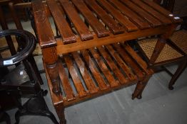 A pair of tradtional stained pine luggage racks having turned legs