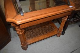 A modern stained frame coffee table having glazed top and bergere canework undertier, approx 68 x