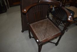 A Victorian corner chair having bergere style seat spindle back, carousel supports and X stretcher