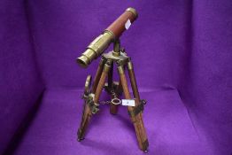 A vintage style small sized telescope with tripod base