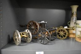 Four miniature model canons including metal and wooden examples