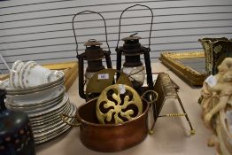 A selection of hardware including copper cooking dish and storm lanterns