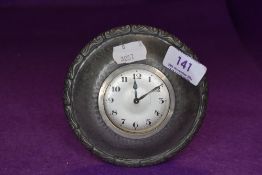 A small Tudric pewter clock with decorated border