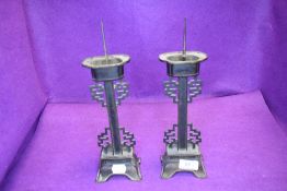 A pair of early 20th century Chinese bronze candle sticks of archaic form