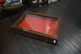 A wooden and glass fronted shallow display case