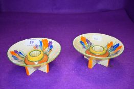 A pair of conical art deco design candle sticks by Clarice Cliff in the autumn crocus design