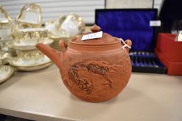 A terracotta Chinese Yixing tea pot decorated with dragon motiff