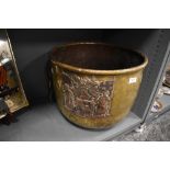 An antique brass worked fire basket or similar with a cooper coat of arms or family crest motif also