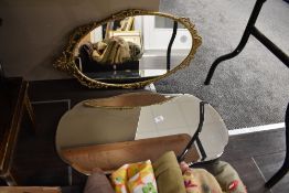 A frameless art deco mirror and a similar brass mirror