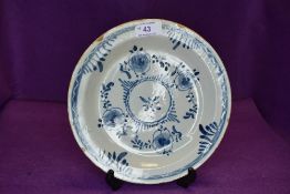 A late 18th century English delft plate or soup bowl in traditional blue and white design with