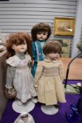 Three porcelain headed dolls