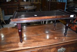 A traditional dark stained bed tray table