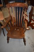 A traditional windsor style kitchen armchair having rail back and H stretcher