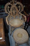 A vintage wicker chair having heart back and similar footstool