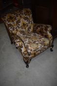 A vintage low seat upholstered armchair, part moquette upholstery