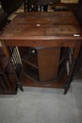 An interesting early 20th Century oak book trolley having square top, twist legs and revolving