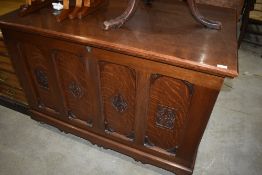 A traditional oak panelled bedding box of large proportions in a gothic style and on castors,