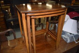 A vintage part walnut nest of three tables on slender legs