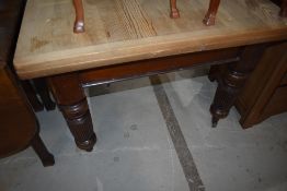 A late Victorian stained frame drawer leaf dining table having stripped top