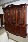 A reproduction hardwood bookcase having glazed upper section over central cupboard base flanked by