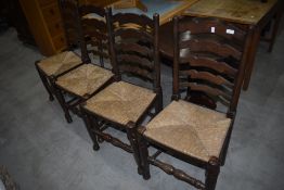 A set of four traditional oak adder back chairs having rush seats
