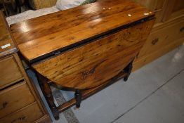 A 19th Century mixed wood table with elements of yew, elm and oak having turned gate leg
