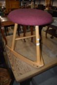 A modern beech frame rocking stool, branded 'Wave Stool'