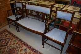An Edwardian mahogany and inlaid salon suite having later blue upholstery