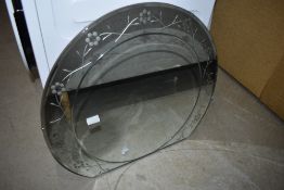 A vintage frameless wall mirror of horse shoe shape, with edged floral border