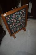 A traditional stained frame woolwork panelled fire screen