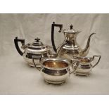 A four piece Edwardian silver tea set of plain oval form having gadrooned rims, hard wood and