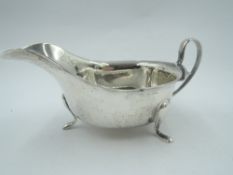 A silver sauce boat having loop handle, trefoil paw feet and frilled rim, Sheffield 1937, Viners