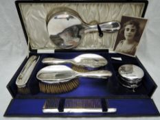 A cased six piece silver dressing table set of plain form including mirror, comb, three brushes &