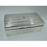 A silver cigarette box of rectangular form having engine turned stripe decoration to lid with