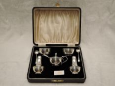 A cased silver five piece cruet set of plain bowl and baluster form, having bakelite liners,