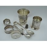 A small selection of HM silver including a beaker having engine turned decoration, two napkin rings,