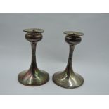 A pair of silver candle sticks having tulip candle holders on tapered stems to weighted circular