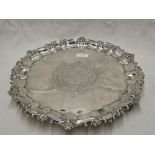 An Edwardian silver salver having moulded raised pie crust rim, trefoil bracket feet and central