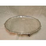 A silver salver of plain circular form having pie crust edge with Norse knot work border and hoof