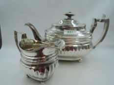 A Georgian silver teapot and sugar bowl of waisted oval form having fluted decoration, bun feet