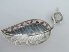 An Edwardian silver caddy spoon modelled as a leaf with pierced borders and stalk handle wound round