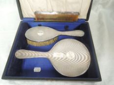 A cased three piece silver dressing table set having engine turned decoration and inscribed 'edith',