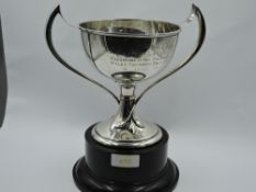 A silver trophy cup having Art Nouveau style twist handles and presentation engraving to sides
