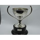 A silver trophy cup having Art Nouveau style twist handles and presentation engraving to sides