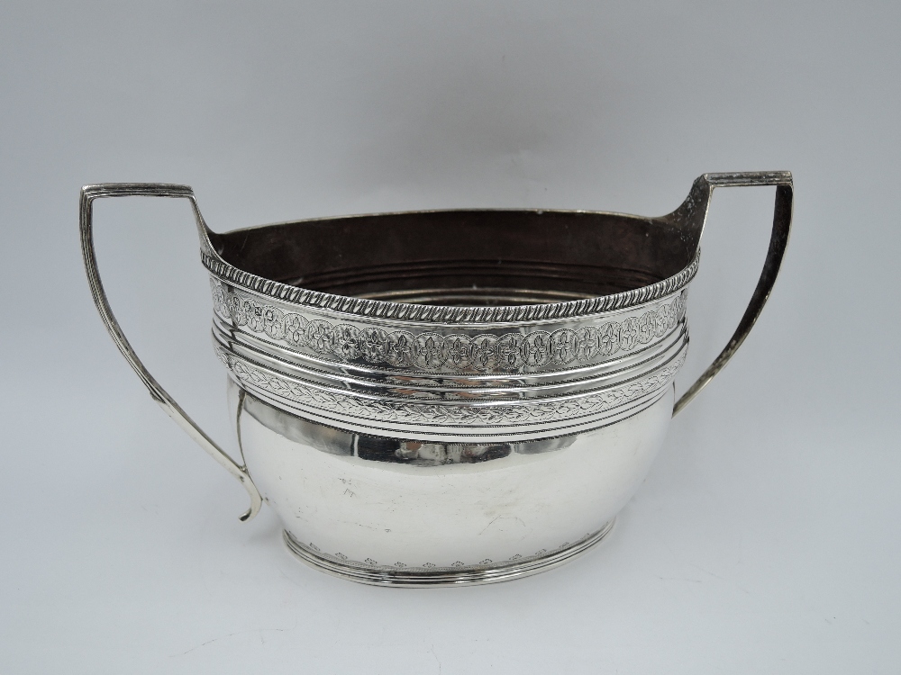 A large Georgian silver sugar bowl of oval form having engraved decoration, gadrooned rim and