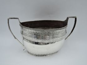 A large Georgian silver sugar bowl of oval form having engraved decoration, gadrooned rim and