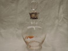 A clear glass spherical decanter on pedestal foot with ball stopper and silver collar, London